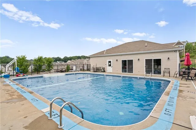 a view of a house with swimming pool and sitting area