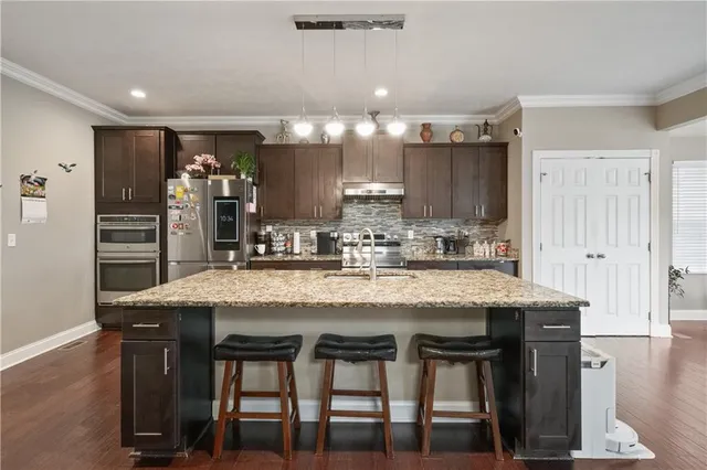 a kitchen with granite countertop and wooden cabinets