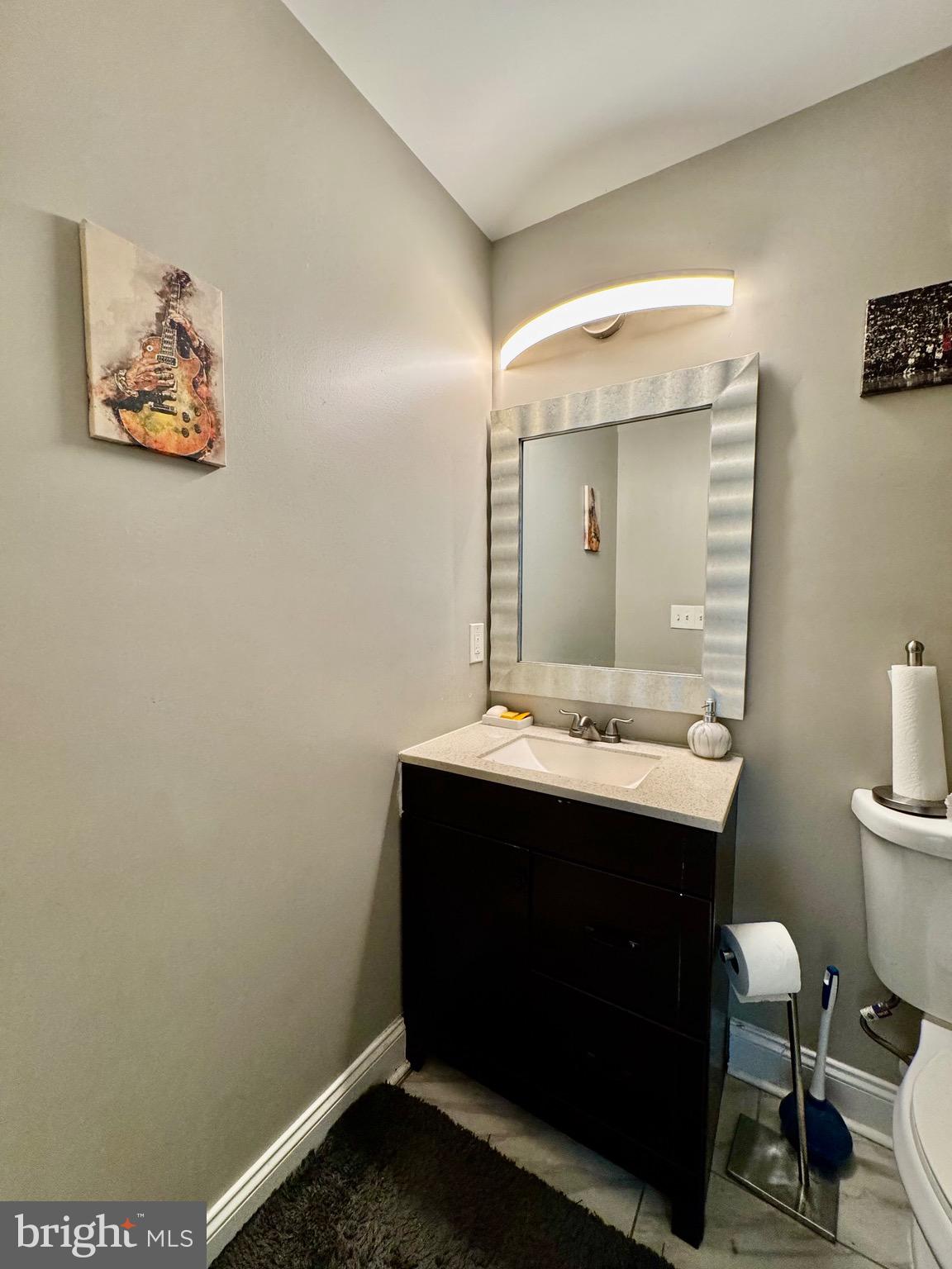 1019 West Fayette Street Baltimore, MD 21223 - Photo 13 of 29 a bathroom with a sink mirror and toilet