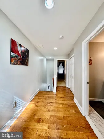 a big room with wooden floor and bathroom