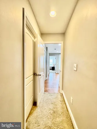 a view of a hallway with wooden floor and a living room