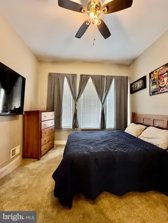 a bedroom with a bed and a flat tv screen on dresser