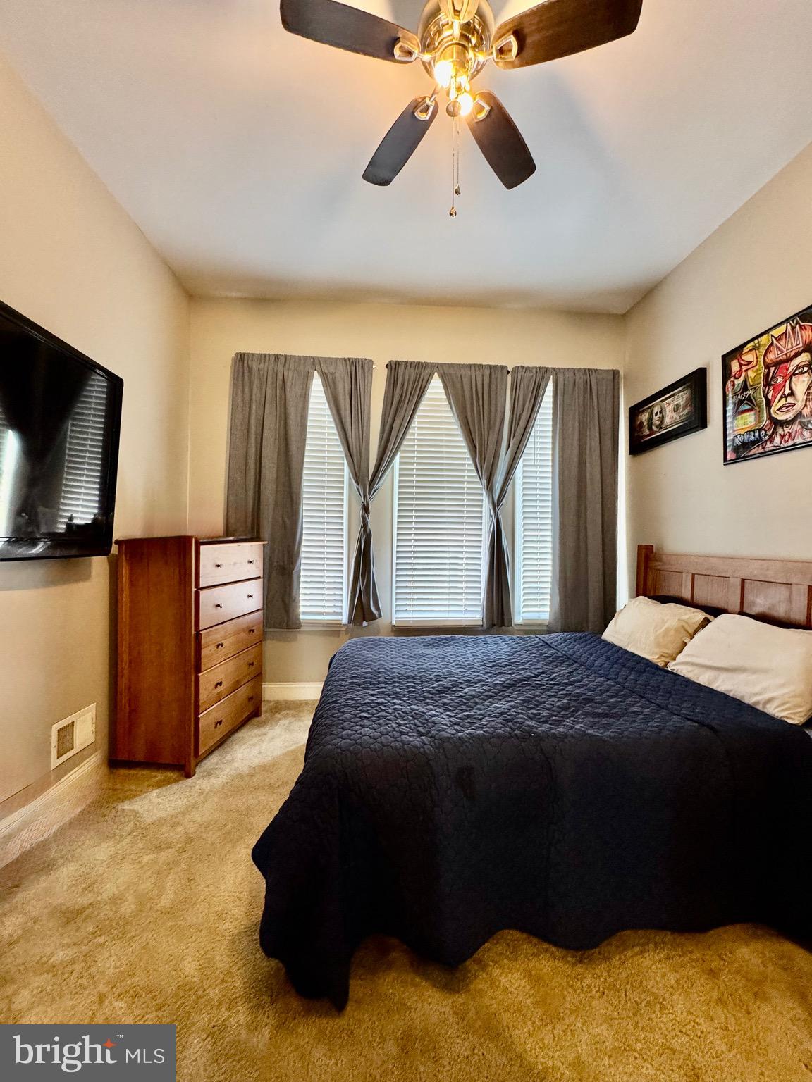 1019 West Fayette Street Baltimore, MD 21223 - Photo 19 of 29 a bedroom with a bed and a flat tv screen on dresser
