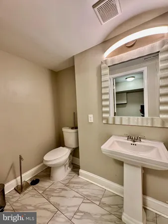 a bathroom with a sink mirror and toilet