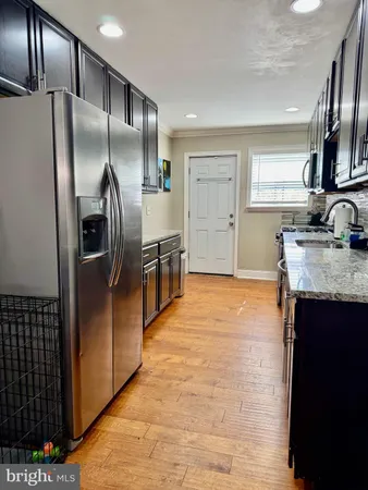 a kitchen with stainless steel appliances granite countertop a refrigerator and a sink