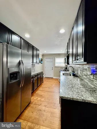 a kitchen with stainless steel appliances granite countertop a sink a stove and a refrigerator