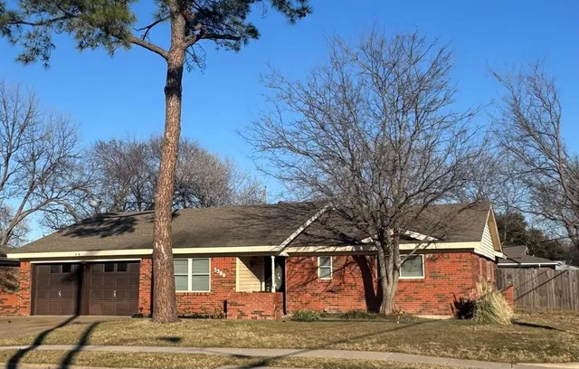 a front view of a house with a tree