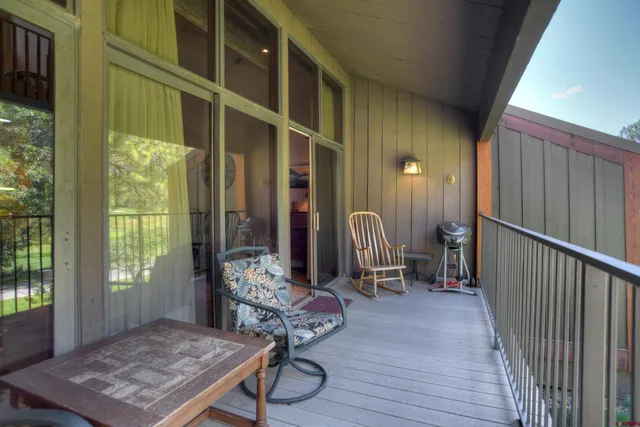 a view of a hallway with wooden floor and windows