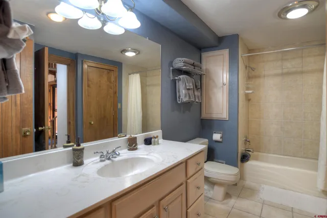 a bathroom with a sink a toilet a mirror and shower