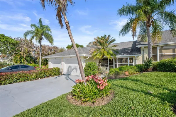 a front view of a house with a yard and potted plants