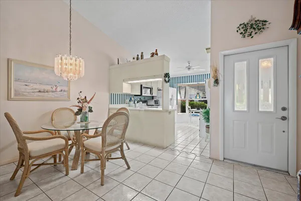 a dining room filled chandelier and kitchen view