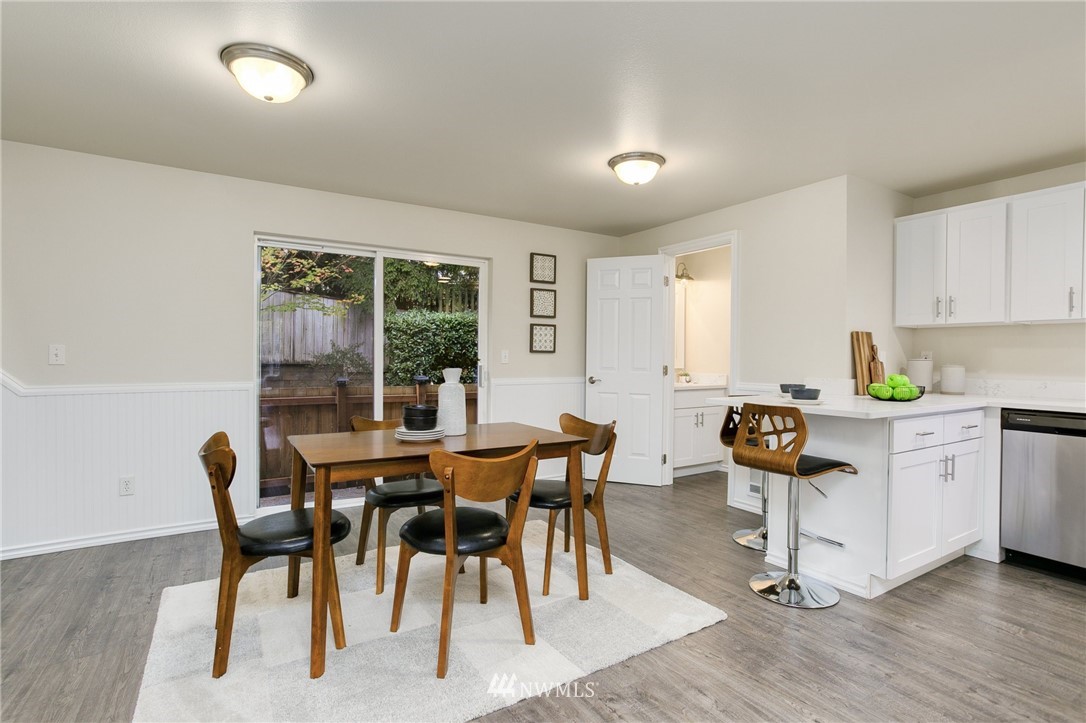 23317 Edmonds Way, Unit 8 Edmonds, WA 98026 - Photo 5 of 26 a kitchen with stainless steel appliances granite countertop a stove a sink a dining table and chairs