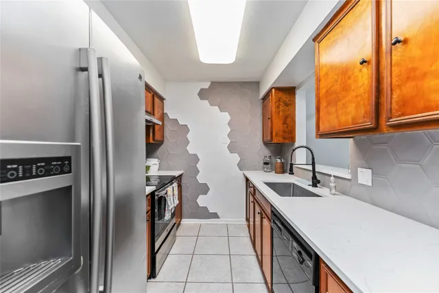 a kitchen with stainless steel appliances granite countertop a sink and a refrigerator
