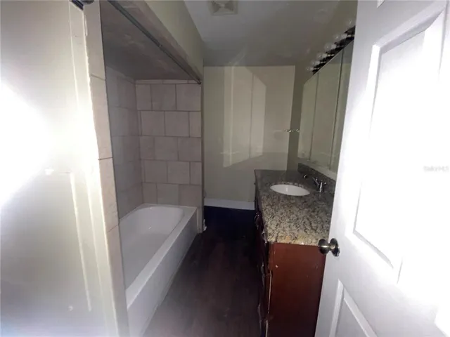 a bathroom with a tub shower and sink
