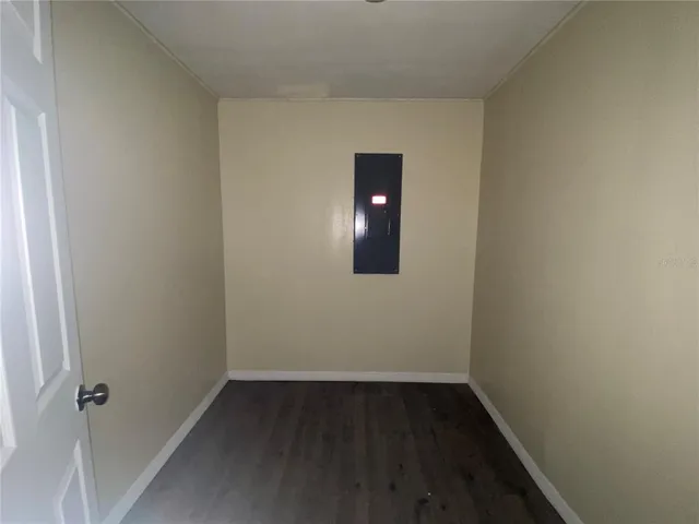 a view of a room with wooden floor and mirror