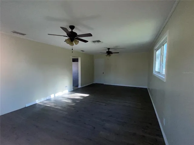 a view of a livingroom with a ceiling fan and window