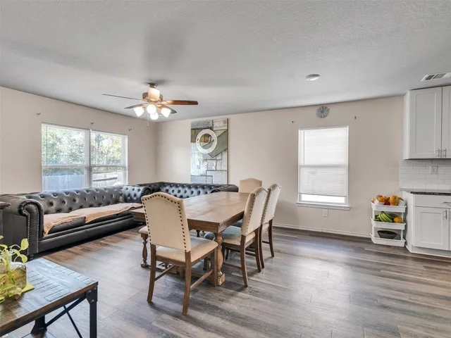 a dining room with furniture a chandelier and wooden floor