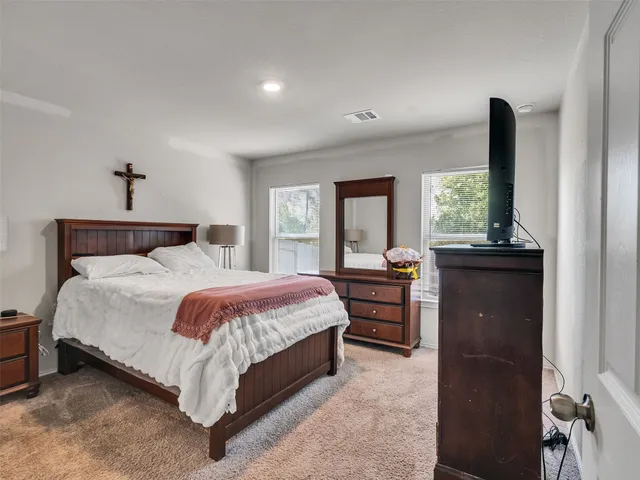 a bedroom with a bed and a dresser next to a window