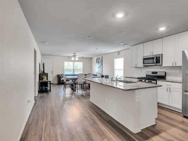a kitchen with cabinets and wooden floor