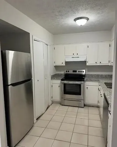 a kitchen with a stove a refrigerator and a sink