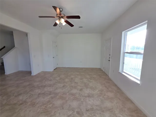 a view of a livingroom with a ceiling fan and window