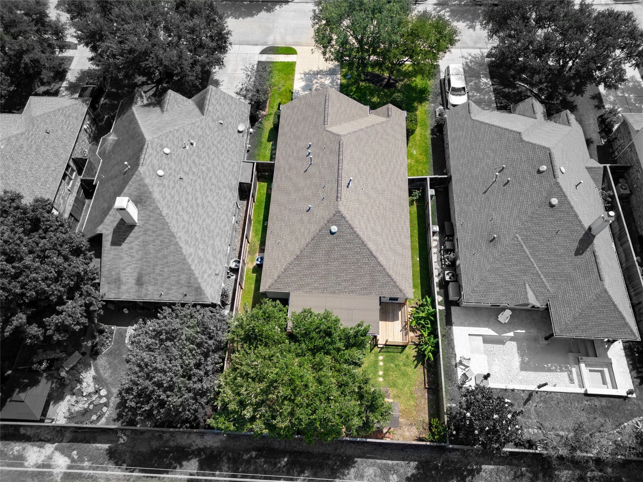 10619 Crownsedge Drive Spring, TX 77379 - Photo 36 of 38 This aerial view showcases a well-maintained suburban home with a fenced backyard featuring a small deck and greenery. It’s nestled between two neighboring homes on a quiet street with mature trees.