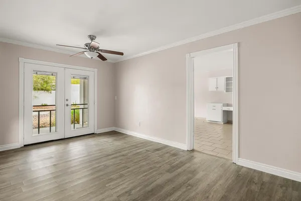 a view of empty room with wooden floor and fan