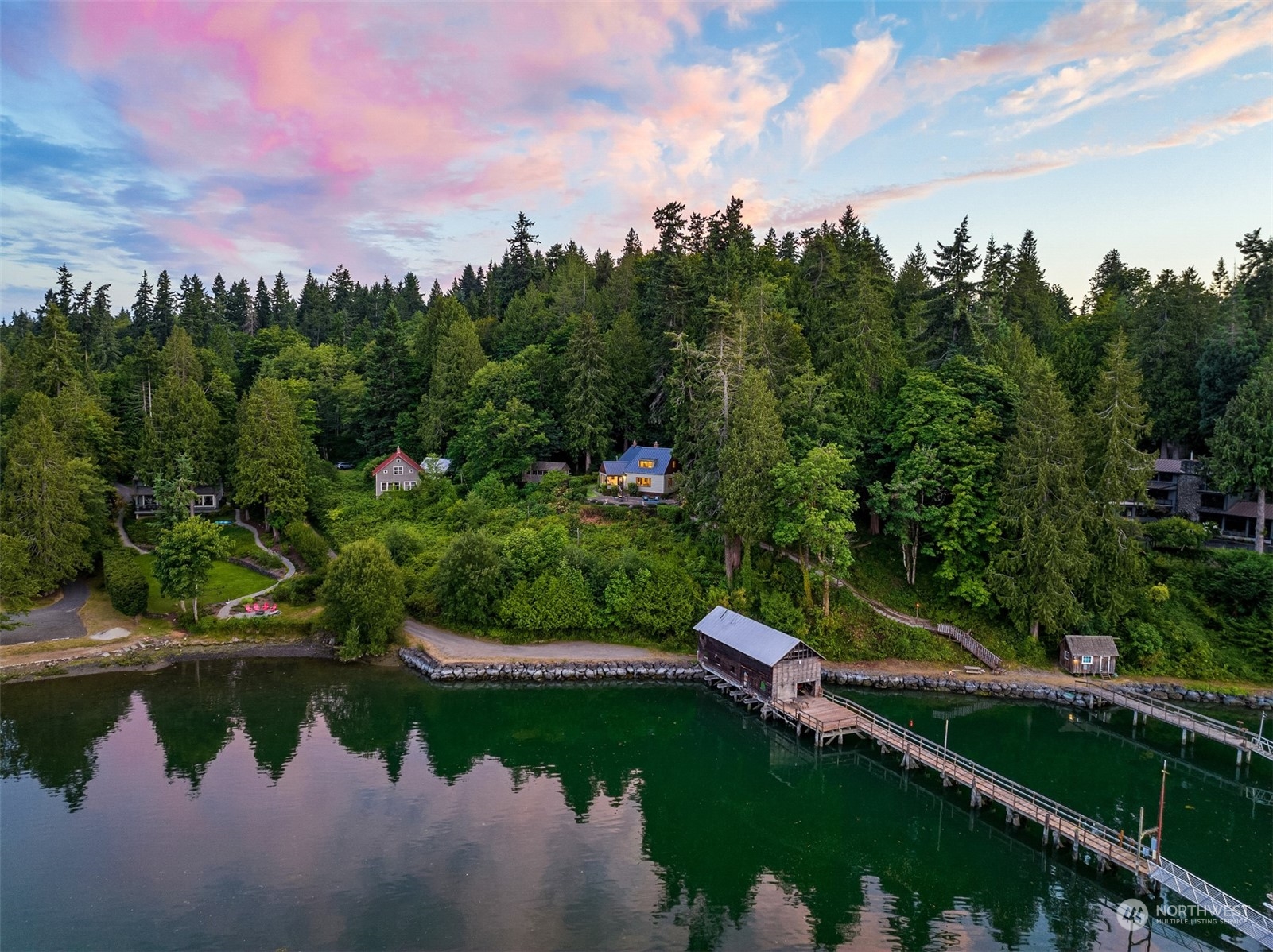 a view of a lake with a yard and large trees