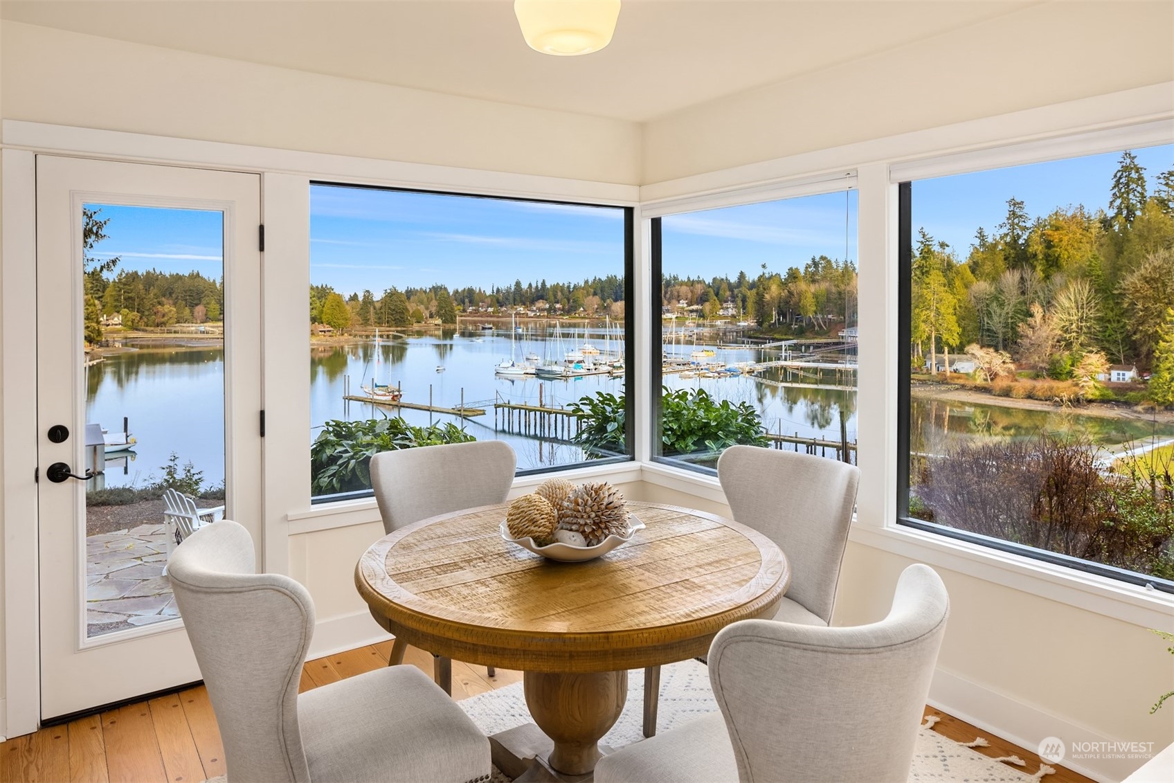 8260 Northeast Hidden Cove Road Bainbridge Island, WA 98110 - Photo 13 of 35 a view of a dining room with furniture wooden floor and a chandelier