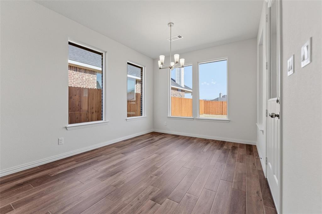 14408 Shooting Star Drive Haslet, TX 76052 - Photo 20 of 25 an empty room with wooden floor chandelier and windows