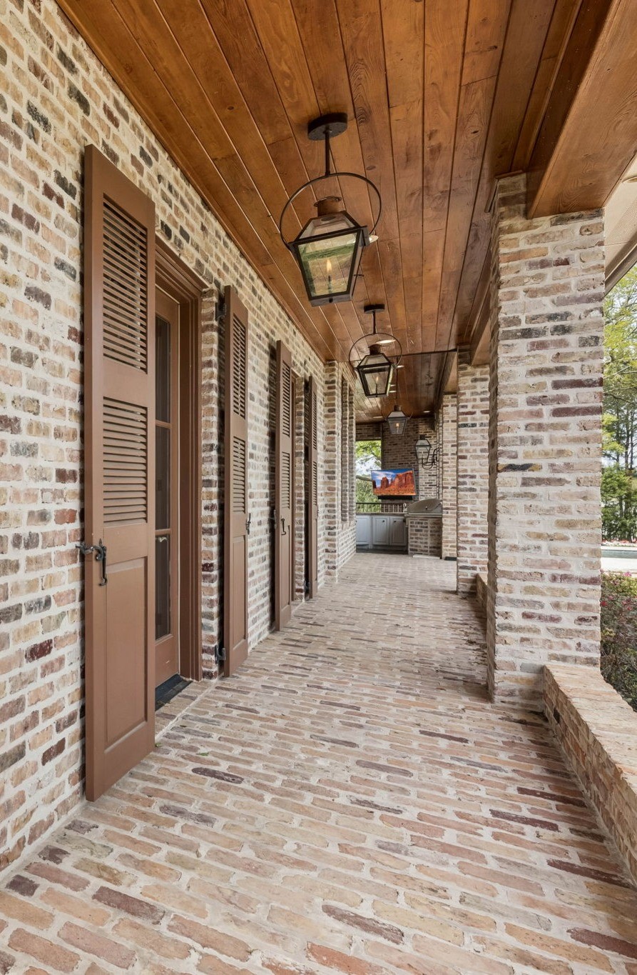 27306 Owosso Court Spring, TX 77386 - Photo 11 of 36 Authentic gas lanterns sourced from New Orleans wrap the entire estate, casting a warm, majestic glow over the reclaimed brick exterior.