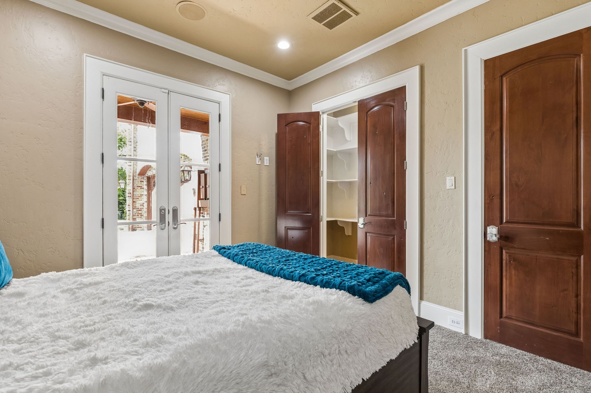 27306 Owosso Court Spring, TX 77386 - Photo 28 of 36 a bedroom with a large bed and a chandelier