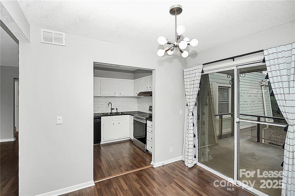 2634 Park Road, Unit D Charlotte, NC 28209 - Photo 11 of 30 a kitchen with kitchen island a counter top space wooden floor and a ceiling fan