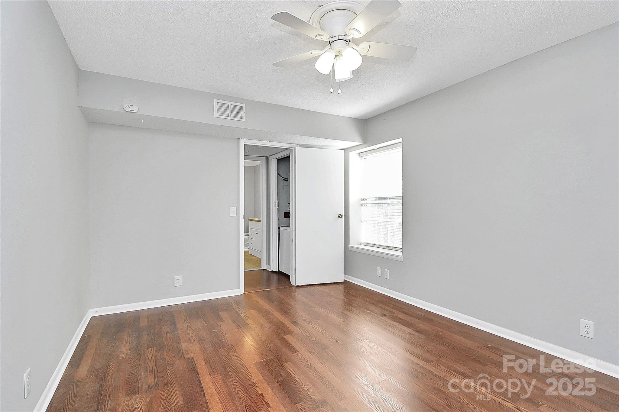 2634 Park Road, Unit D Charlotte, NC 28209 - Photo 23 of 30 an empty room with wooden floor and window