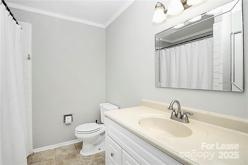 2634 Park Road, Unit D Charlotte, NC 28209 - Photo 26 of 30 a bathroom with a sink a toilet and a mirror