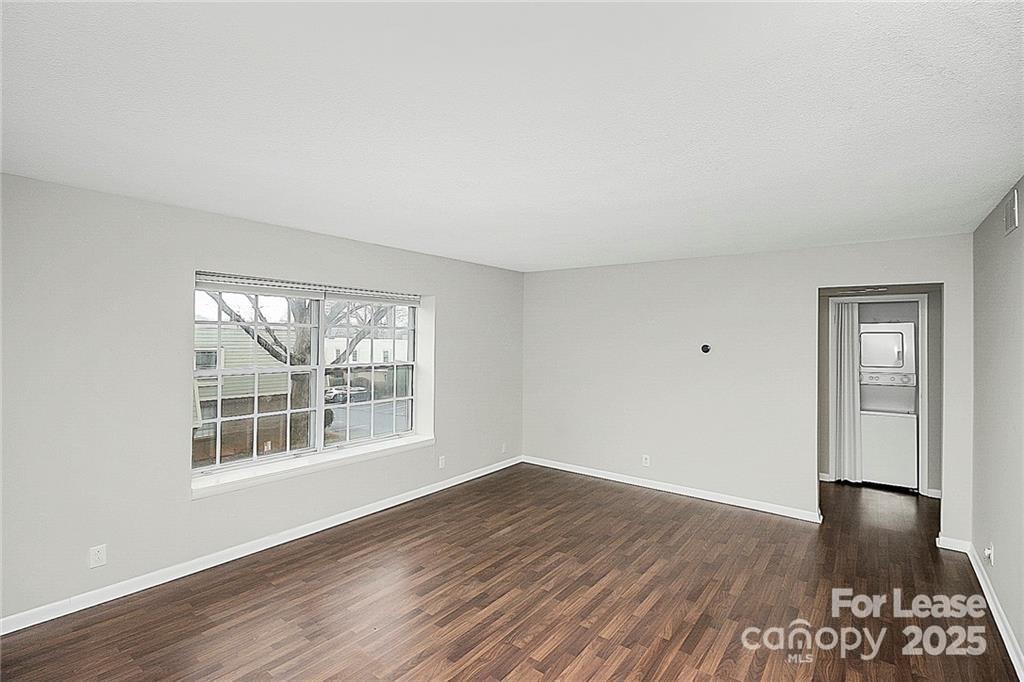 2634 Park Road, Unit D Charlotte, NC 28209 - Photo 4 of 30 a view of an empty room with wooden floor and a window