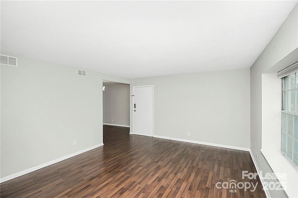 2634 Park Road, Unit D Charlotte, NC 28209 - Photo 7 of 30 an empty room with wooden floor and windows