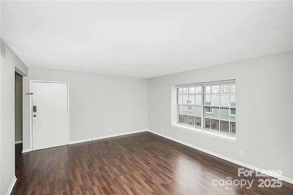 2634 Park Road, Unit D Charlotte, NC 28209 - Photo 9 of 30 an empty room with wooden floor and windows