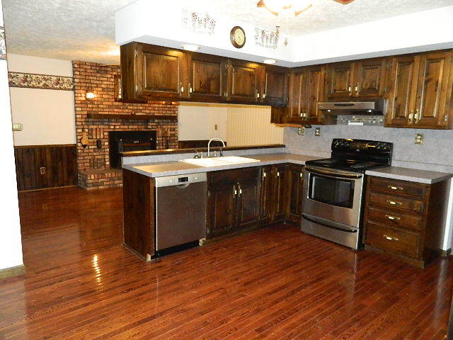 4788 Seven Hills Road Clinton, IL 61727 - Photo 26 of 46 a kitchen with stainless steel appliances granite countertop a stove a sink dishwasher and a microwave oven with wooden floor