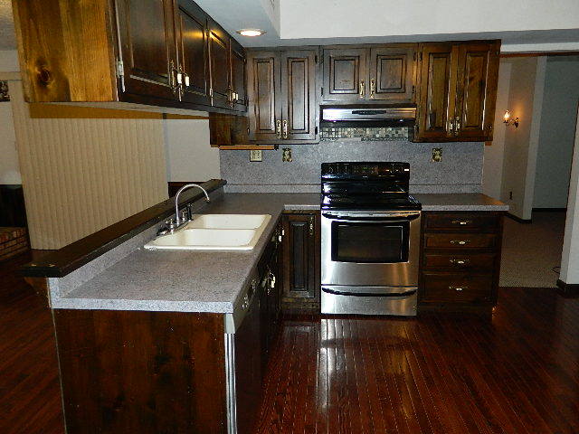 4788 Seven Hills Road Clinton, IL 61727 - Photo 27 of 46 a kitchen with kitchen island granite countertop a stove a sink and a microwave