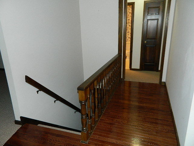4788 Seven Hills Road Clinton, IL 61727 - Photo 37 of 46 a view of a hallway with wooden floor and staircase