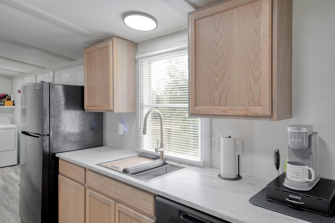 209 Fallwell Street Liberty Hill, TX 78642 - Photo 12 of 25 a kitchen with a refrigerator and a sink