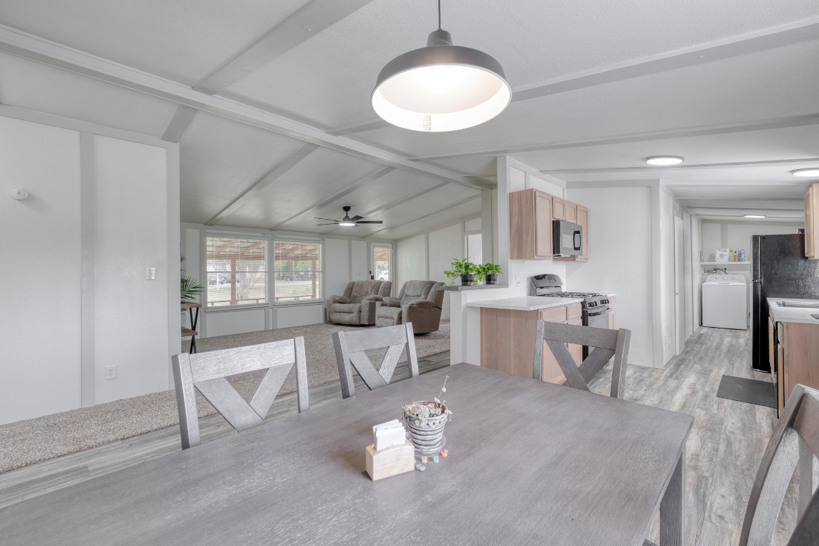 209 Fallwell Street Liberty Hill, TX 78642 - Photo 14 of 25 a view of a dining room with furniture a kitchen and chandelier