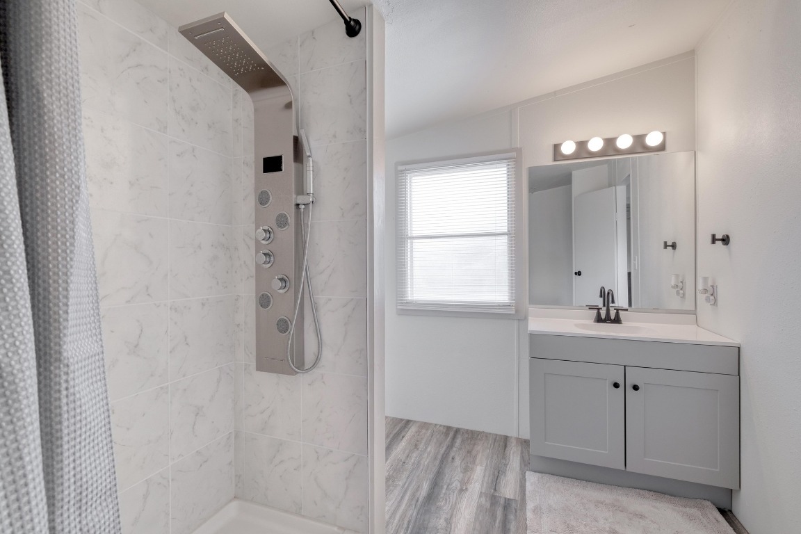 209 Fallwell Street Liberty Hill, TX 78642 - Photo 17 of 25 a bathroom with a granite countertop sink a light fixture and a window