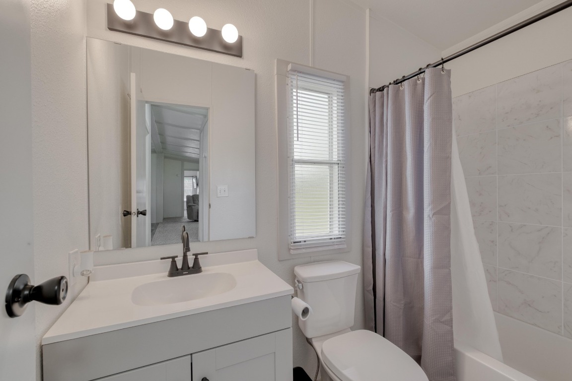 209 Fallwell Street Liberty Hill, TX 78642 - Photo 19 of 25 a bathroom with a sink a toilet and a mirror