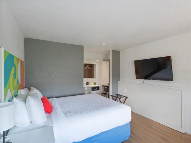 a bedroom with a bed and a flat screen tv