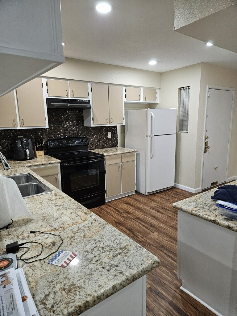 14515 Wunderlich Drive, Unit 306 Houston, TX 77069 - Photo 6 of 24 a kitchen with stainless steel appliances kitchen island granite countertop a sink stove and refrigerator