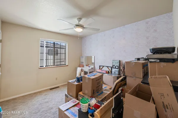 an empty room with a ceiling fan and a window