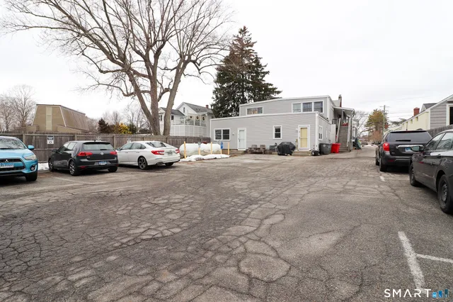 a view of a white house with large windows and a table