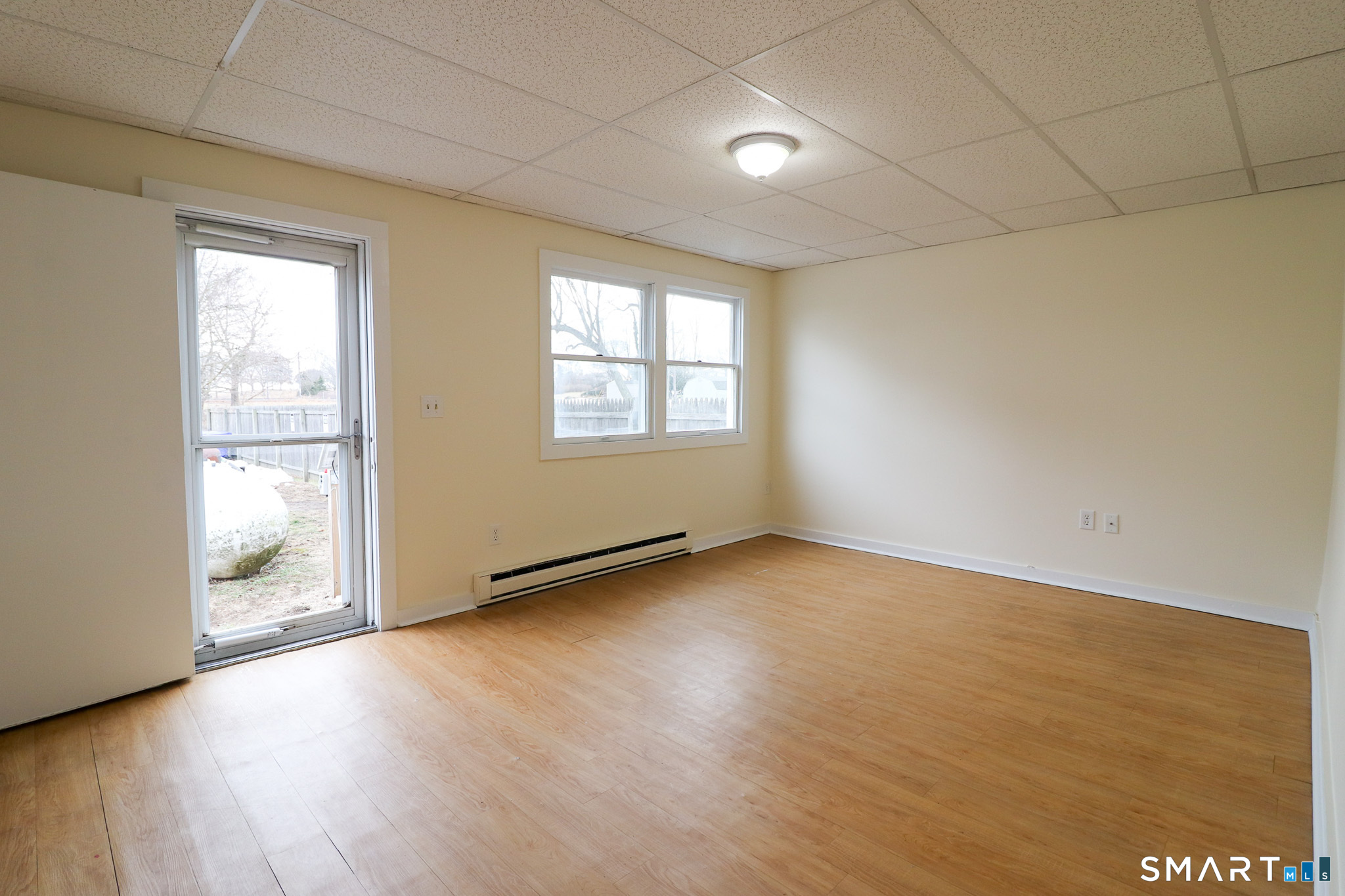 374 Main Street, Unit C Niantic, CT 06357 - Photo 3 of 31 an empty room with wooden floor and windows